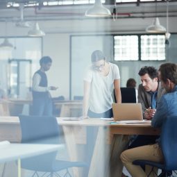 Image of people discussing something over a laptop in an office